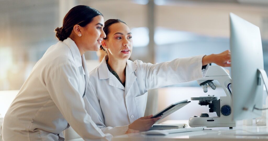 Scientists reviewing research data on a computer during clinical trials.